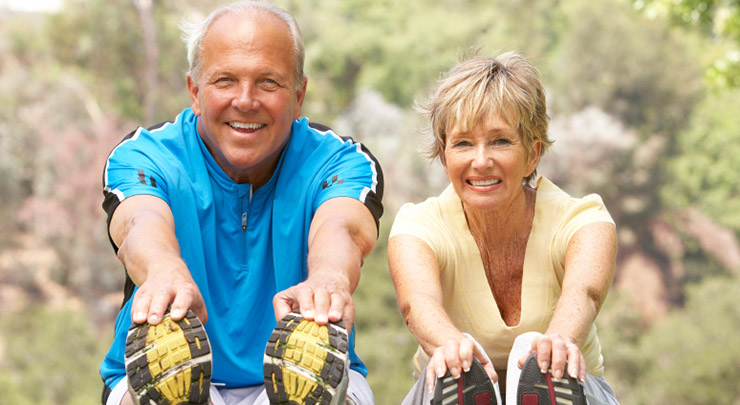 Senior Couple Exercising In Park