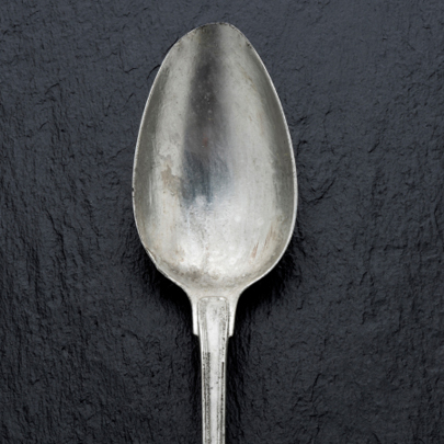 Old Spoon on Black Slate Background