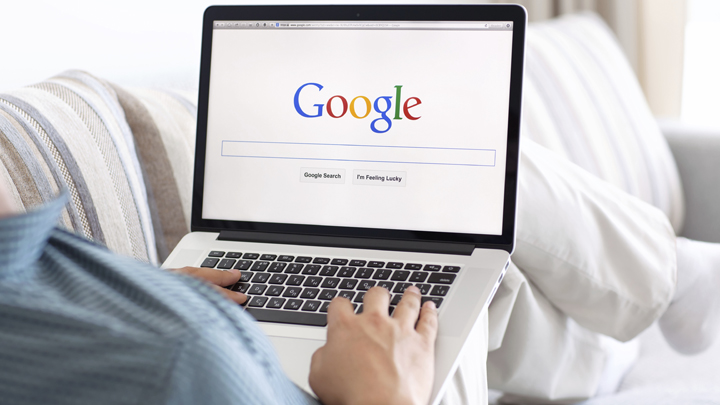 man sitting at the MacBook retina with site Google on the screen