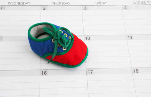 Colorful Baby bootie on a claendar background. Could be used for concepts such as due date, baby announcement, baby shower invitation, pregnancy announcement or planning to have a baby.