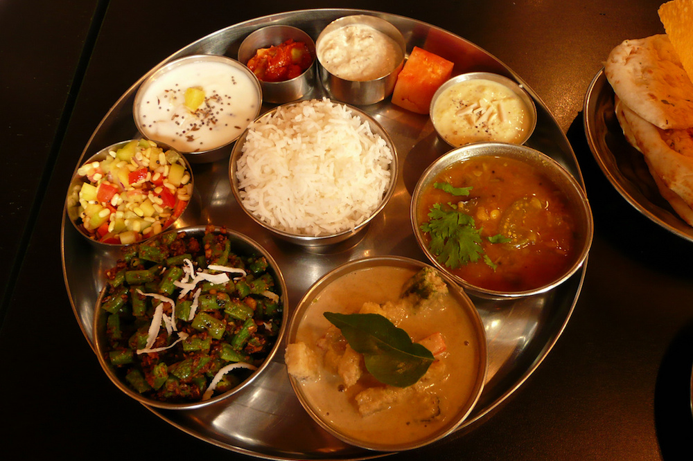 A traditional thali with rice, several different dishes and dessert