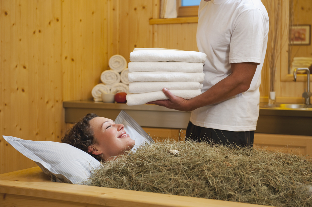 A woman enjoys a hay bath