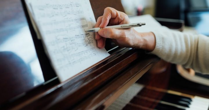 sheet-music-piano person writing on piano sheet music