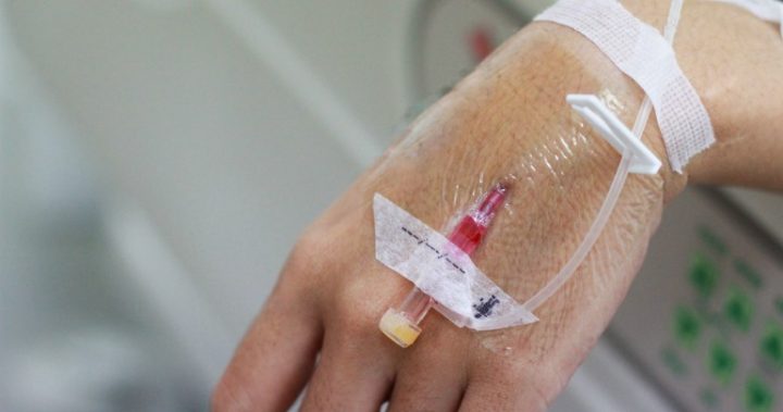 cancer treatment a hand with a needle in it