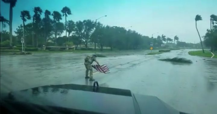 soldier irma solider picks flag out of mud