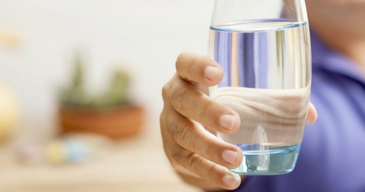 hand holding glass of water hand holding glass of water