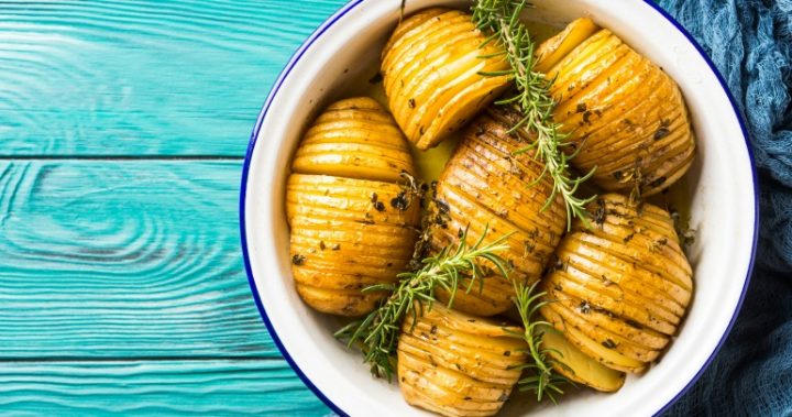 Potatoes baked with herbs in oven in enamel tin. Rustic style Potatoes baked with herbs in oven in enamel tin. Rustic style