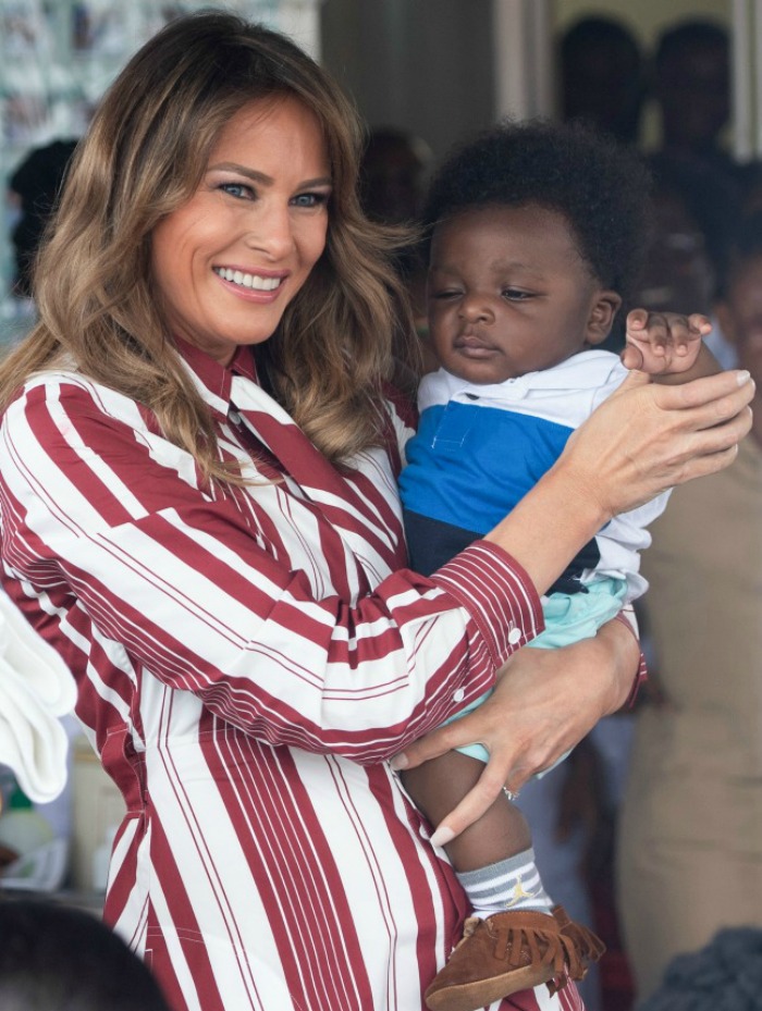 Melania Trump was all smiles as she cuddled with a child during the first day of her African visit. 