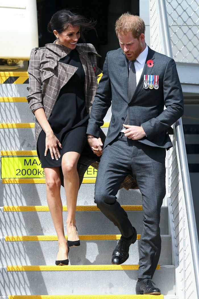 Prince Harry escorts Meghan down the plane stairs. Source: Getty.