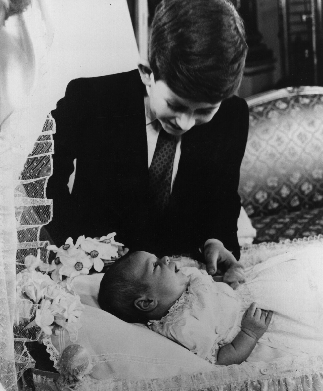 Prince Charles gazes down at his brother Andrew in 1960. Source: Getty.