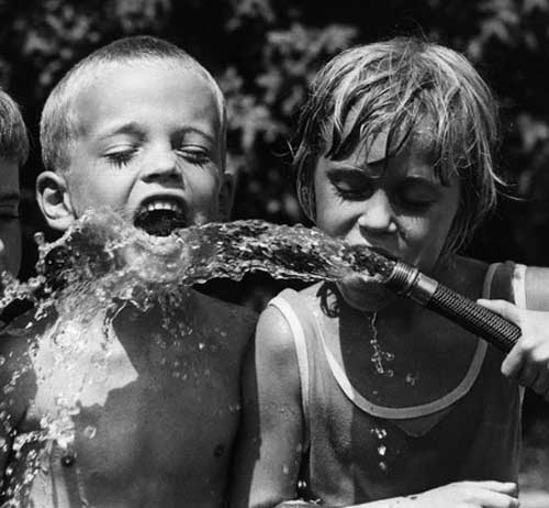 Children Drinking from Garden Hose